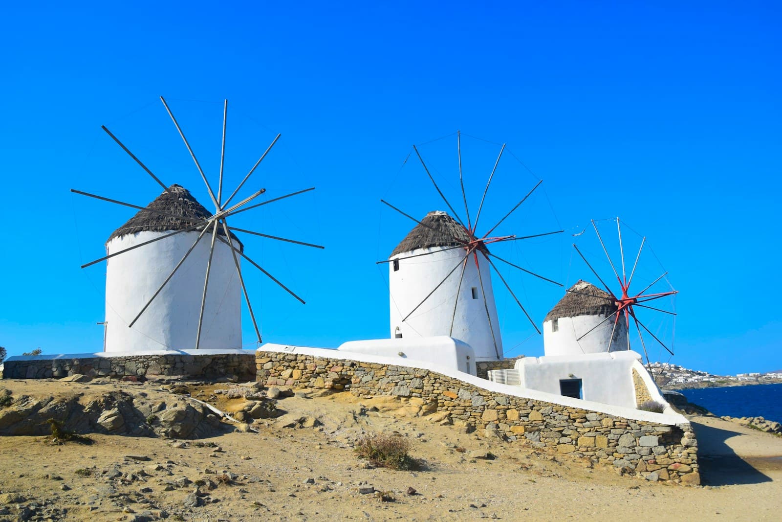 Moulins de Mykonos au-dessus des maisons blanches en bord de mer