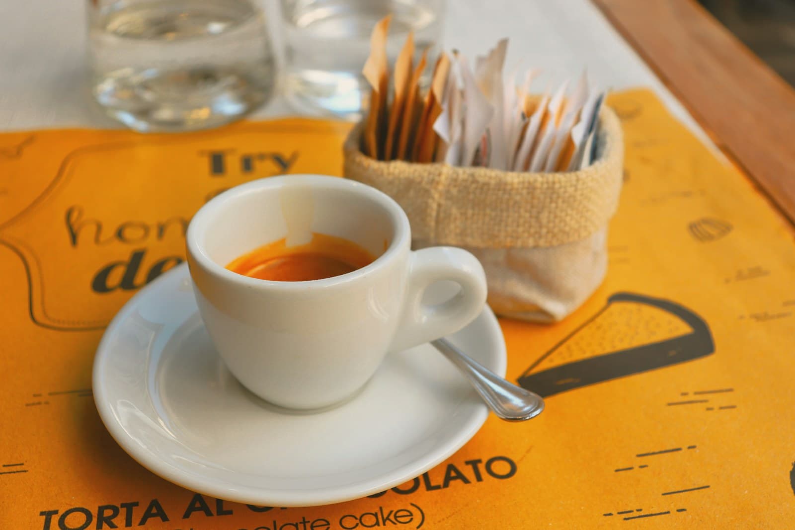 Italian espresso shot in a small white cup on a bar counter