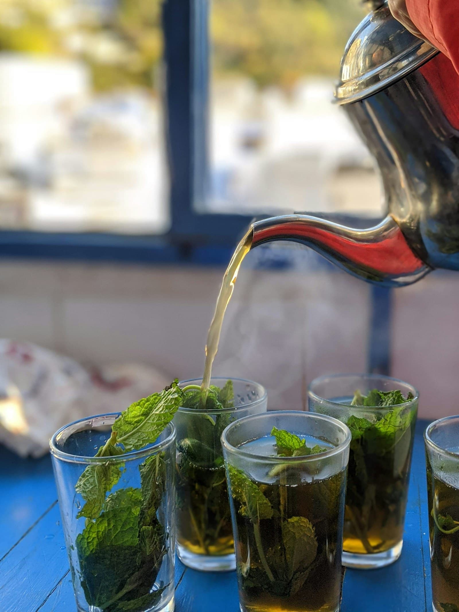Moroccan mint tea poured from height into glasses