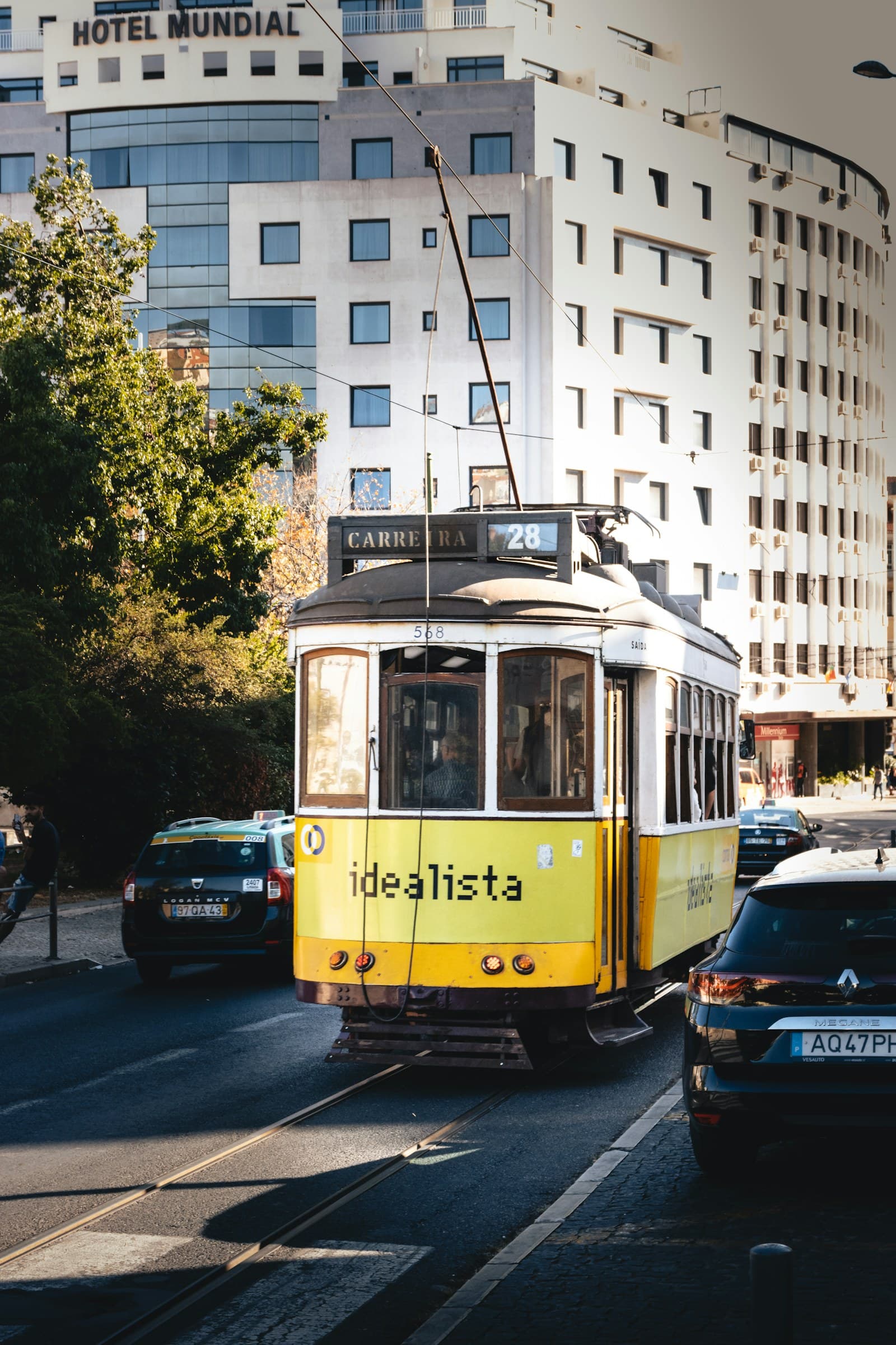 Yellow Lisbon tram climbing a narrow Alfama street