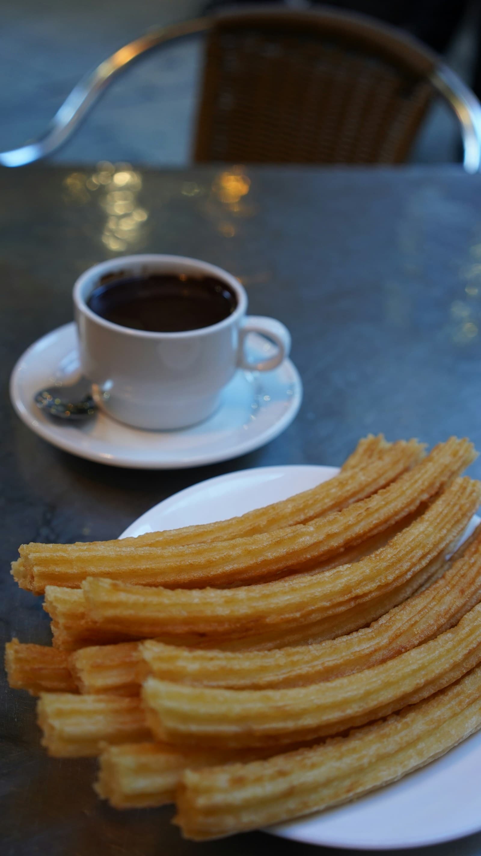 Churros à côté d'une tasse de chocolat chaud épais