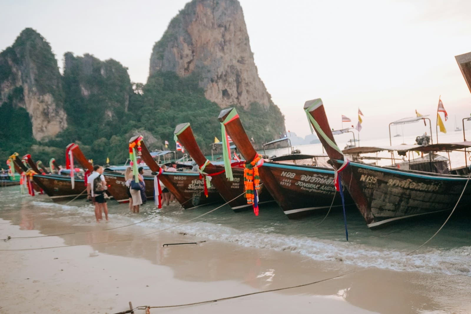 Longtail boat sur eau turquoise sous les falaises calcaires de Railay